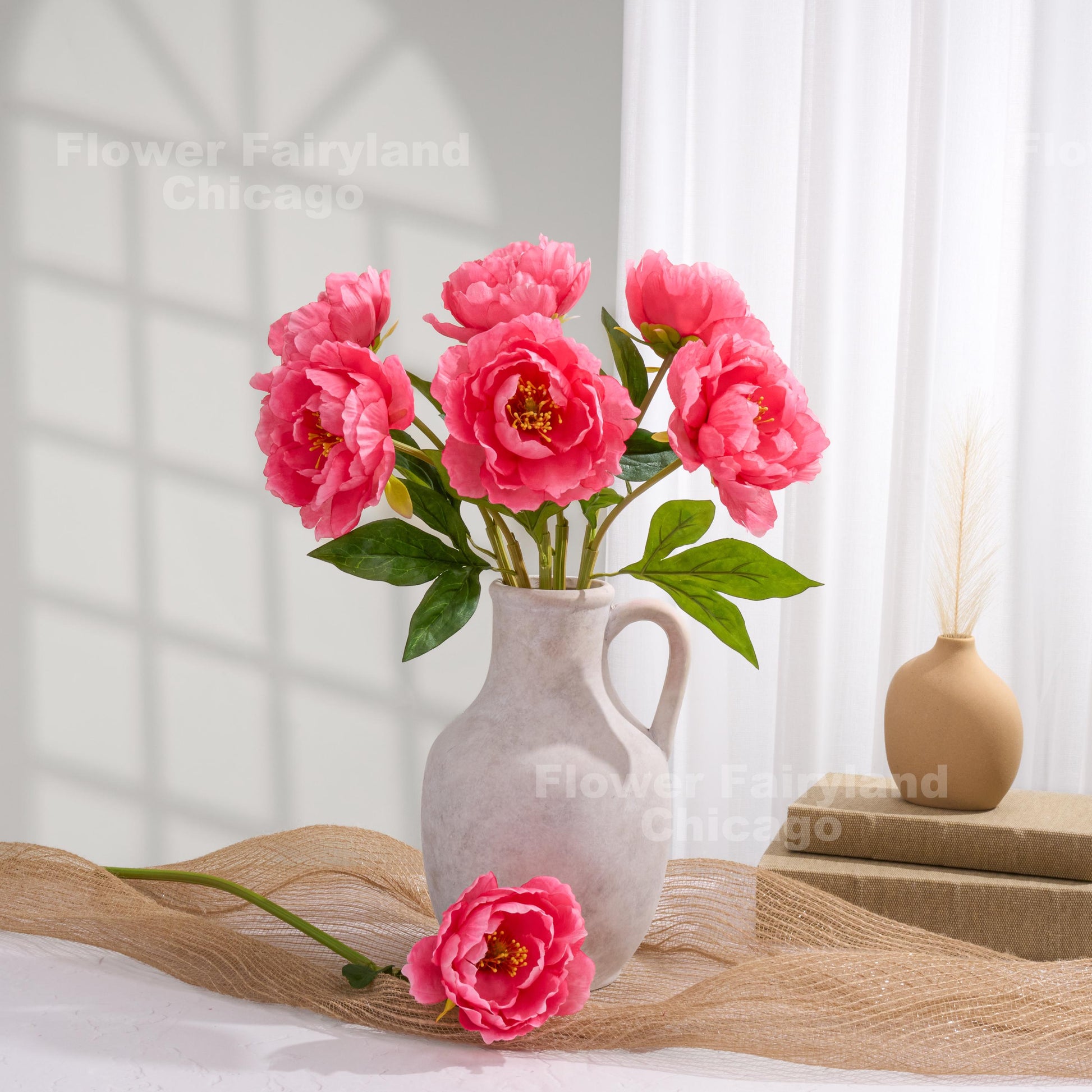 Bright pink faux peony arrangement in a vase