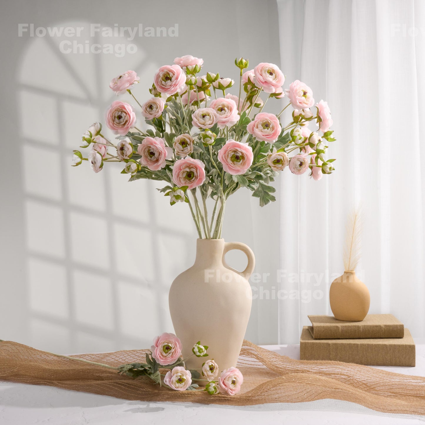 Soft pink faux ranunculus stems in a vase