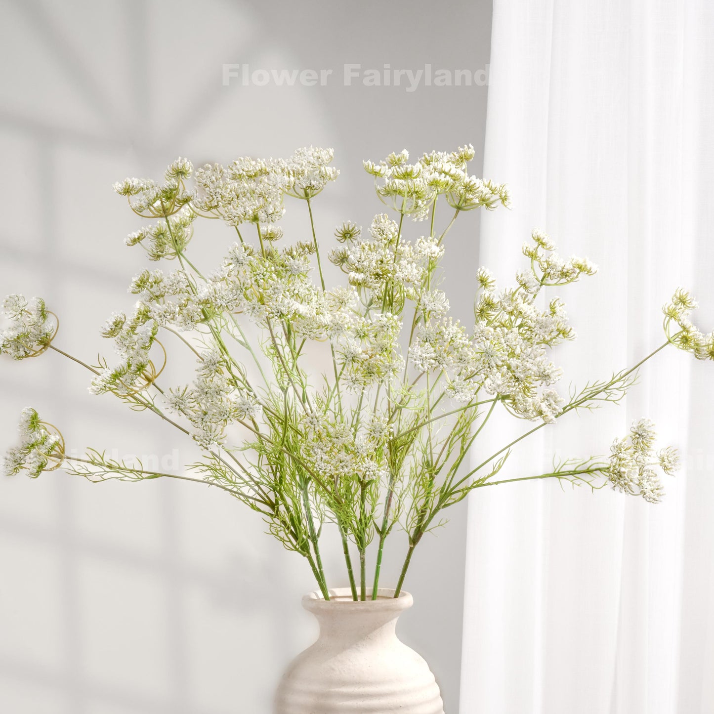 White faux Queen Anne's lace stems styled in a vase