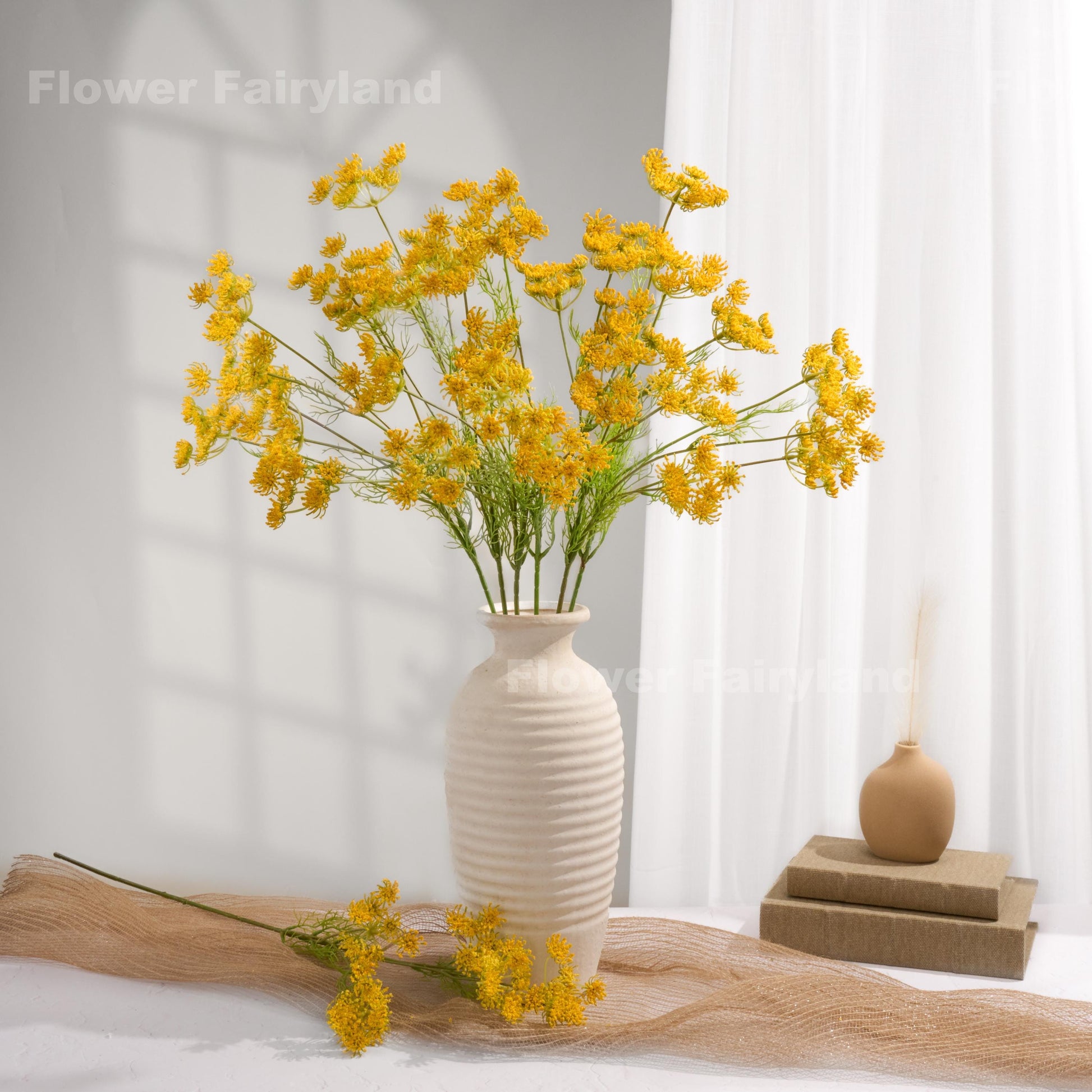 Yellow faux Queen Anne's lace arrangement in a white vase