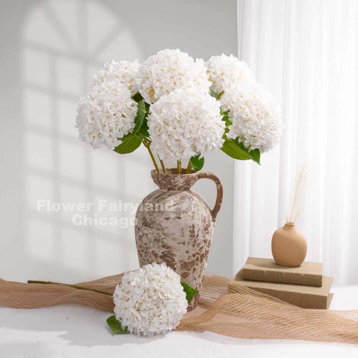 White Grand Bloom faux hydrangeas styled by a window