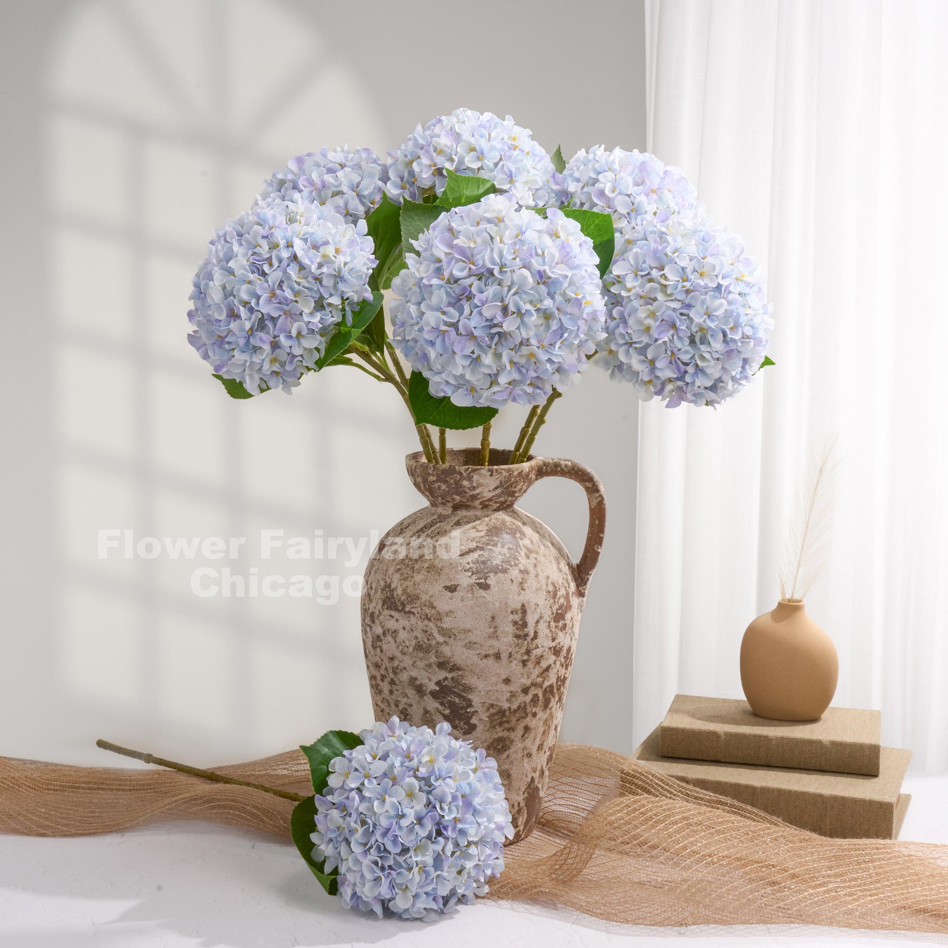 Light violet blue Grand Bloom faux hydrangeas styled in a pitcher vase