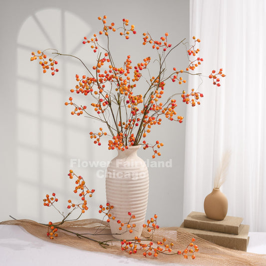 Orange faux berry branches styled in a cream vase for fall home decor