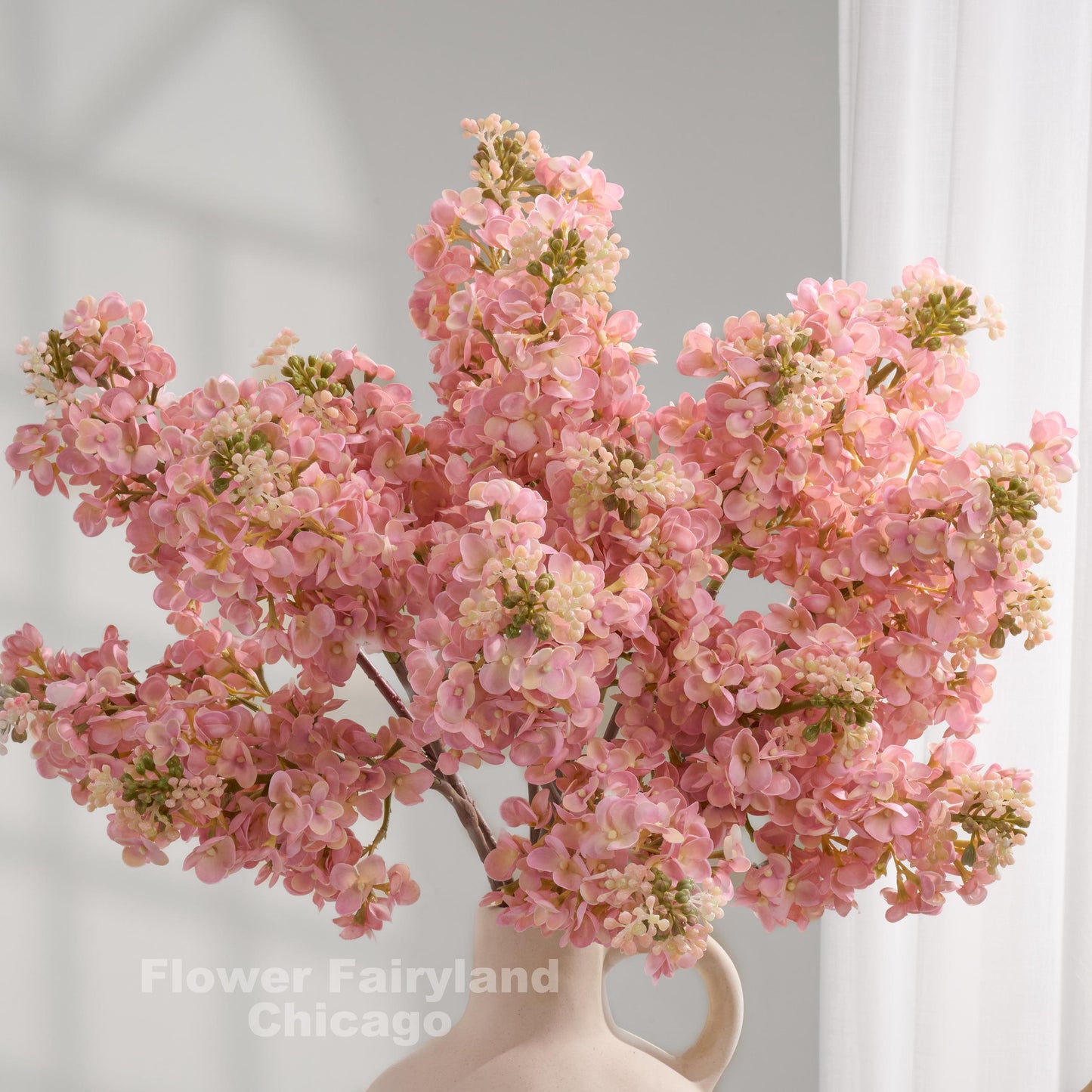 Light pink real touch lilac stems in a vase