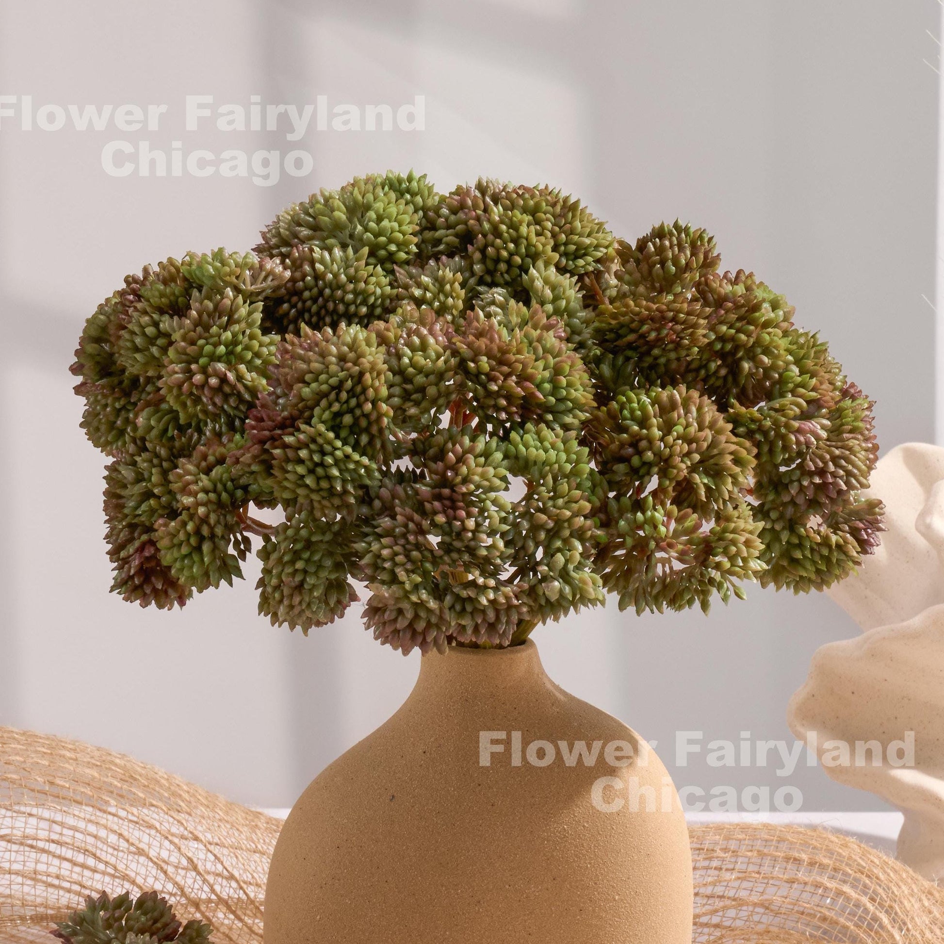 Mauve and sage green sedum clusters styled in a vase