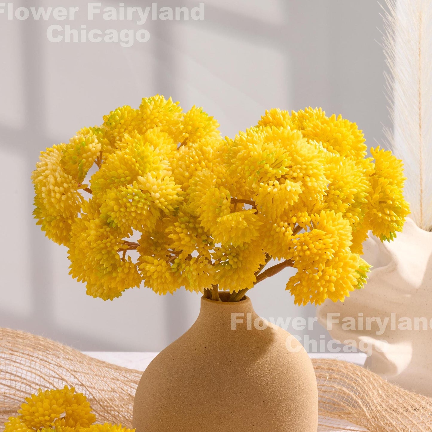 Yellow sedum clusters styled in a vase