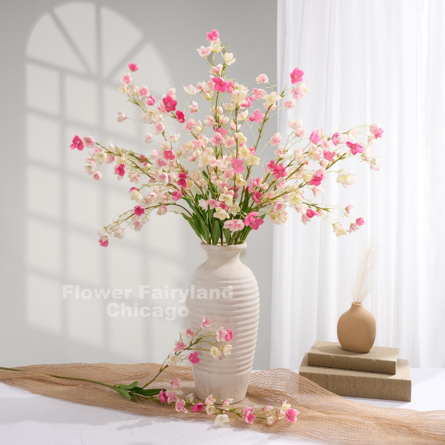 Pink faux Enkianthus stems styled in a vase