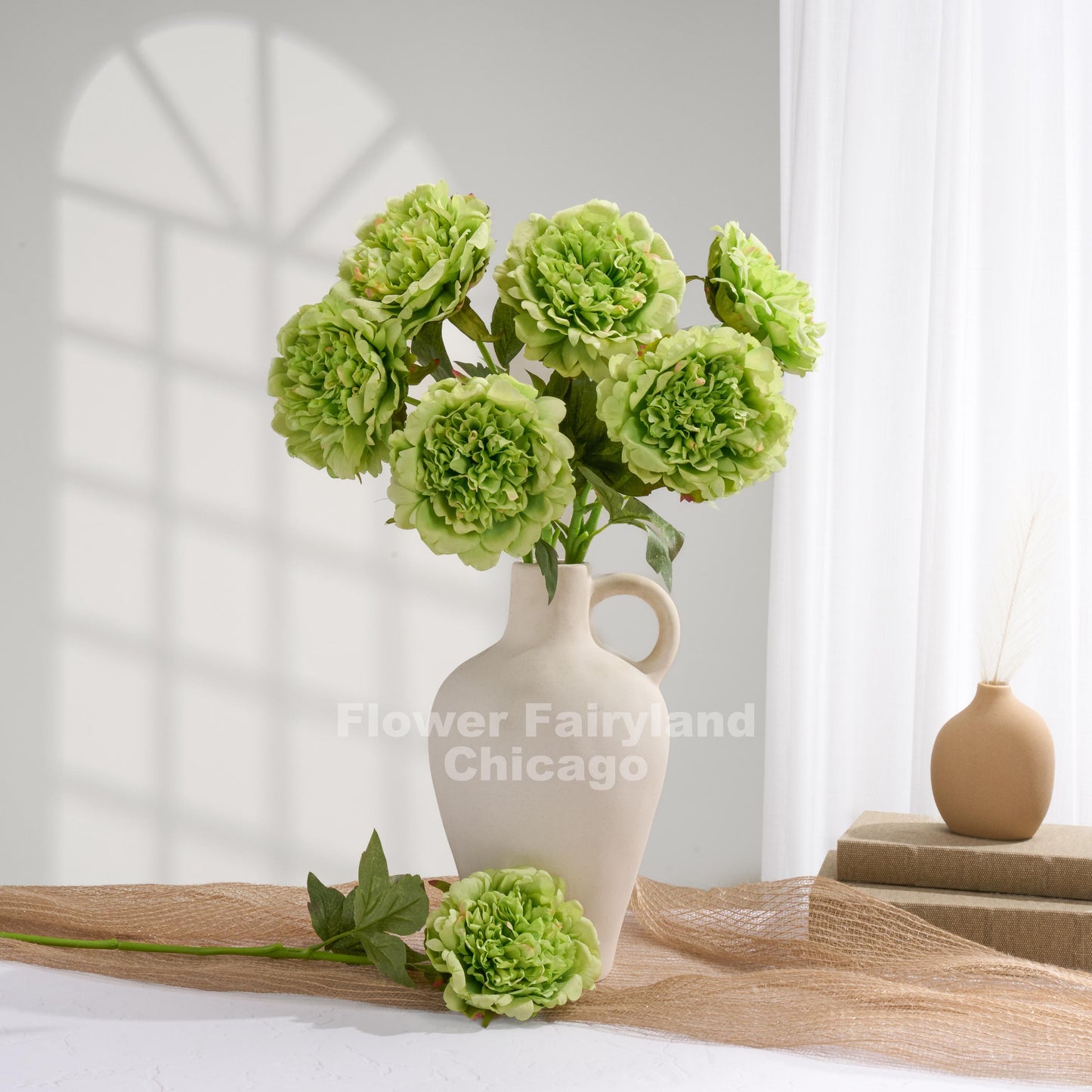 Green faux peonies styled in a home decor scene