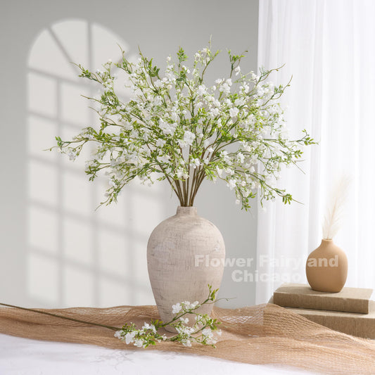 White faux wax flowers styled in a vase