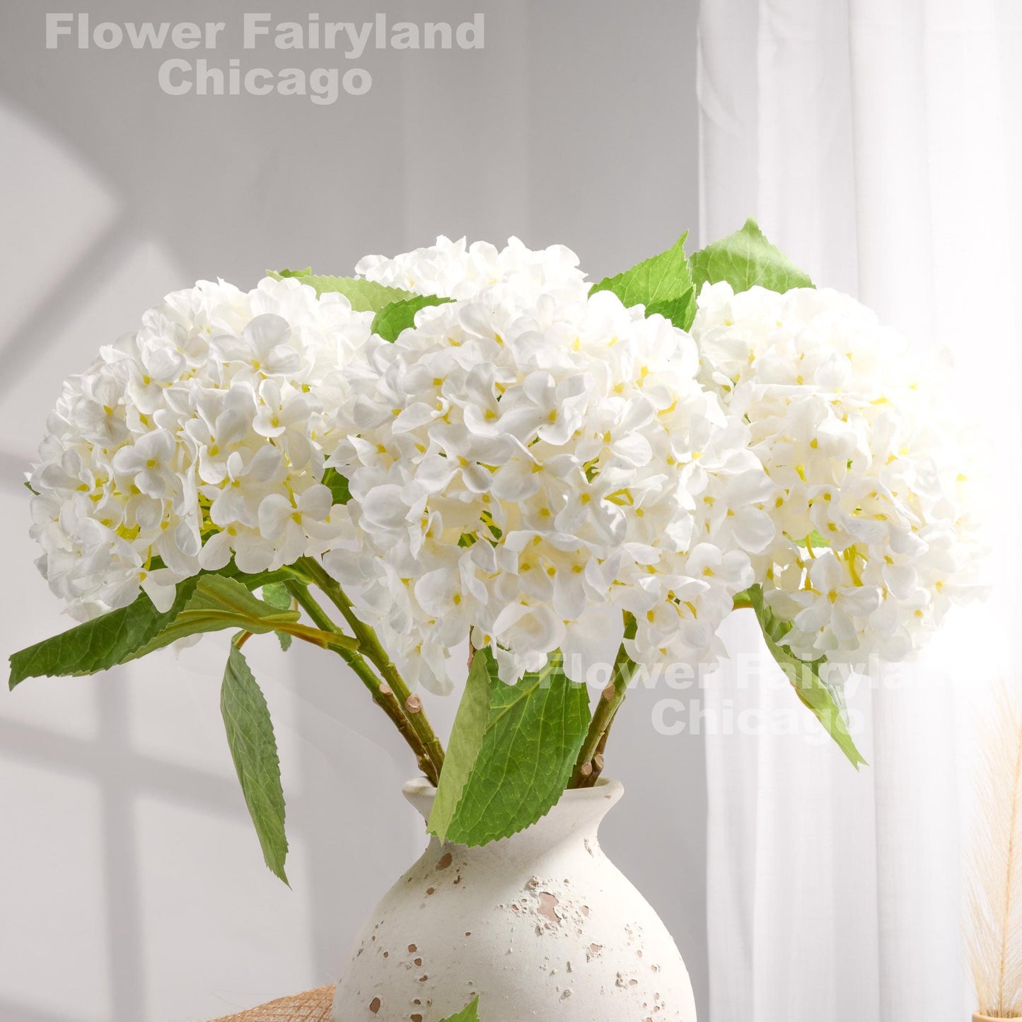 White faux hydrangeas styled in a vase