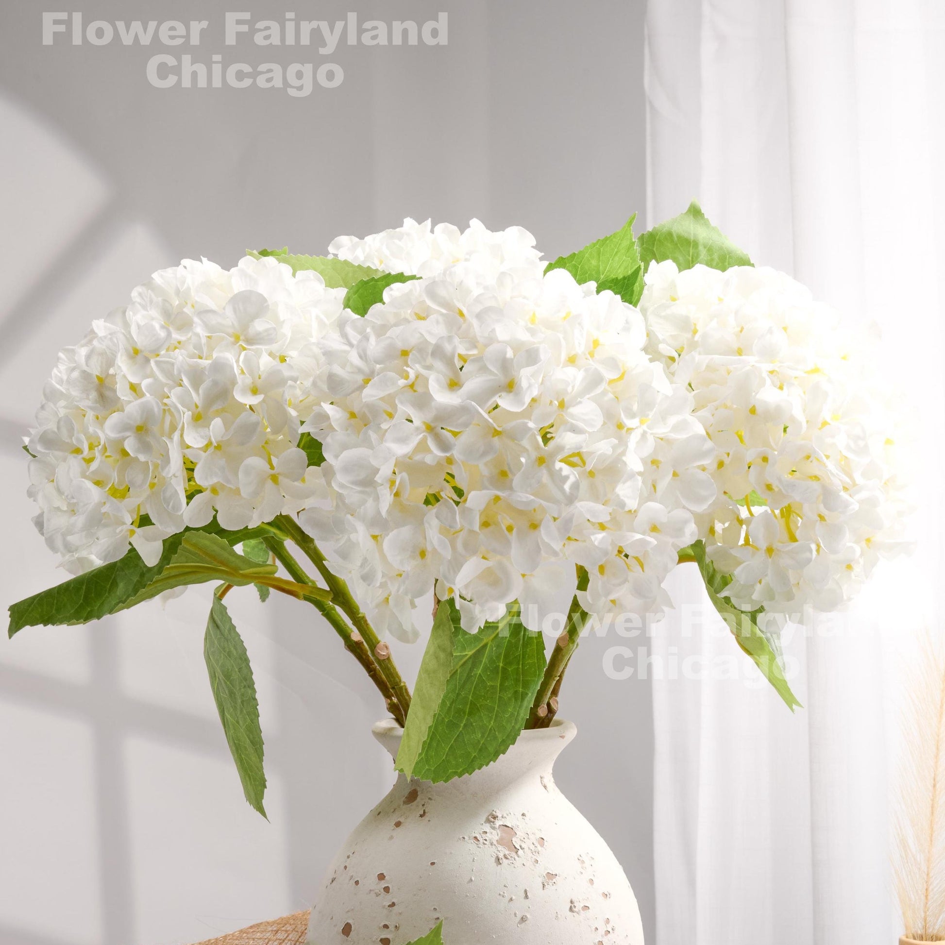White faux hydrangeas styled in a vase