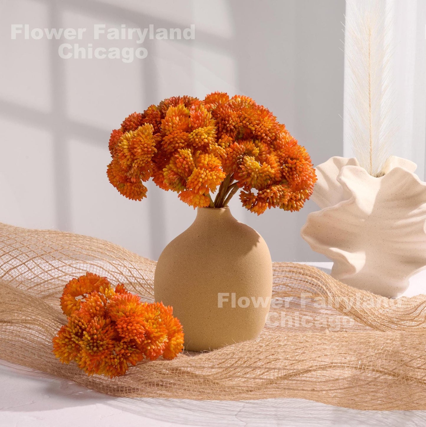 Orange sedum clusters styled in a vase