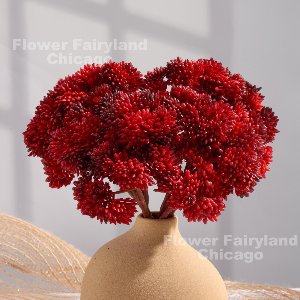 Red sedum clusters styled in a vase