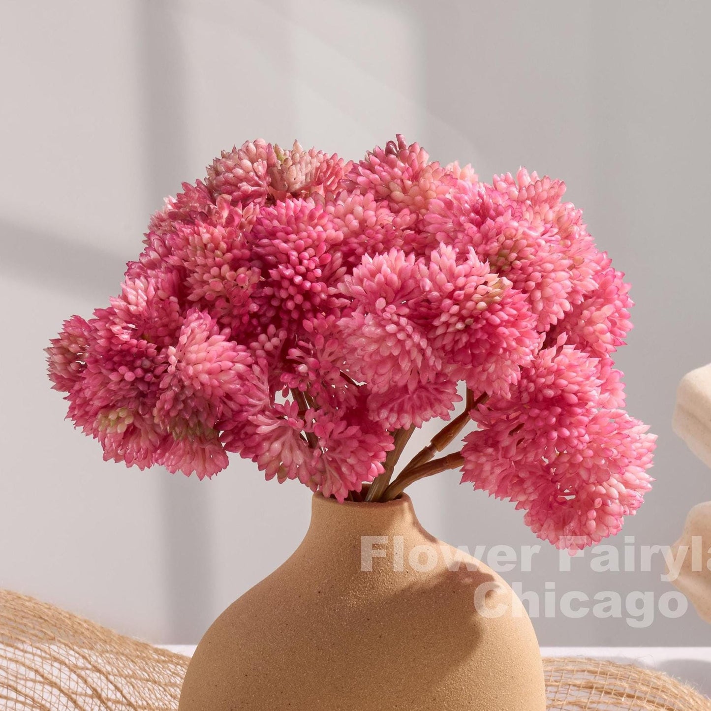 Pinkish mauve sedum clusters styled in a vase