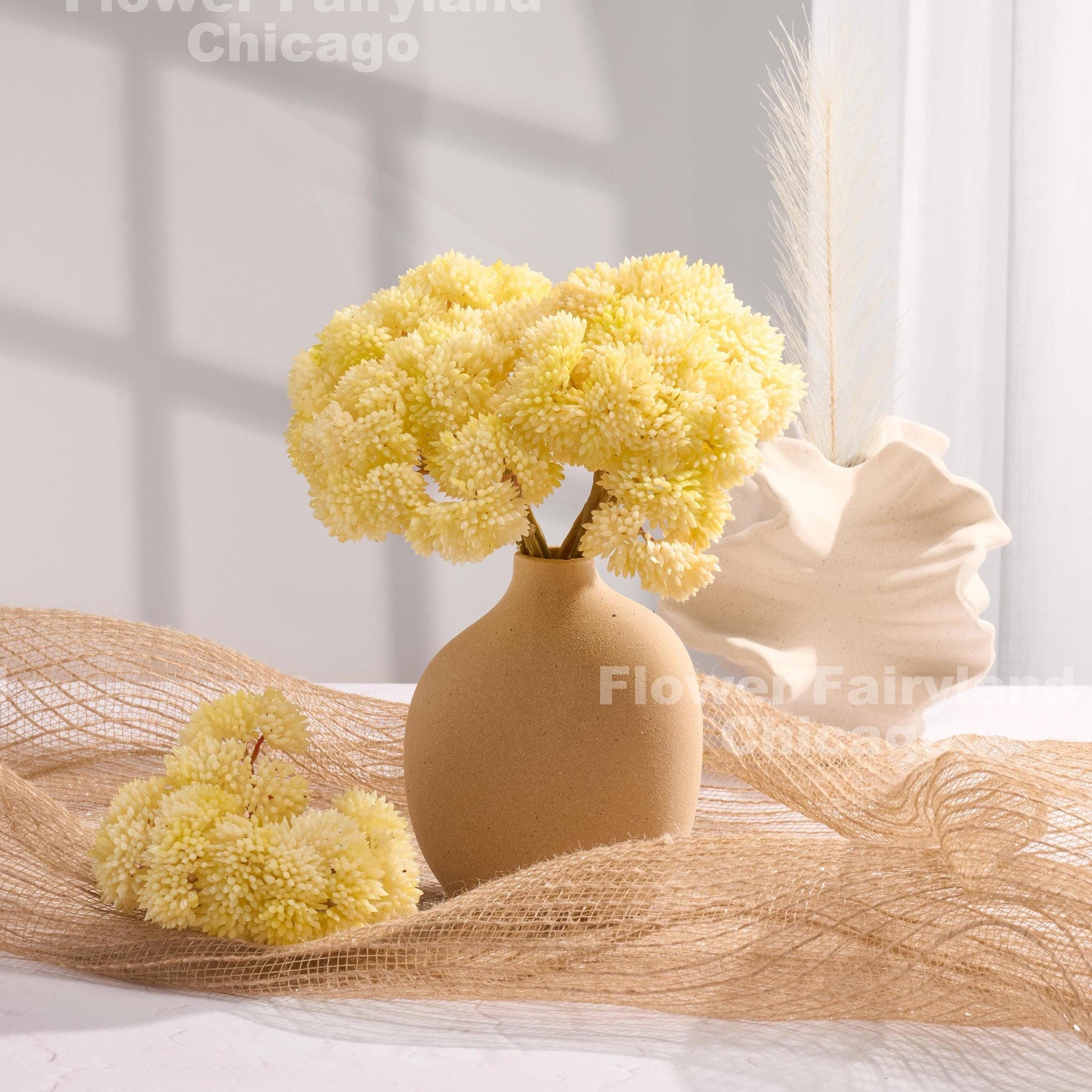 Yellowish cream sedum clusters styled in a vase