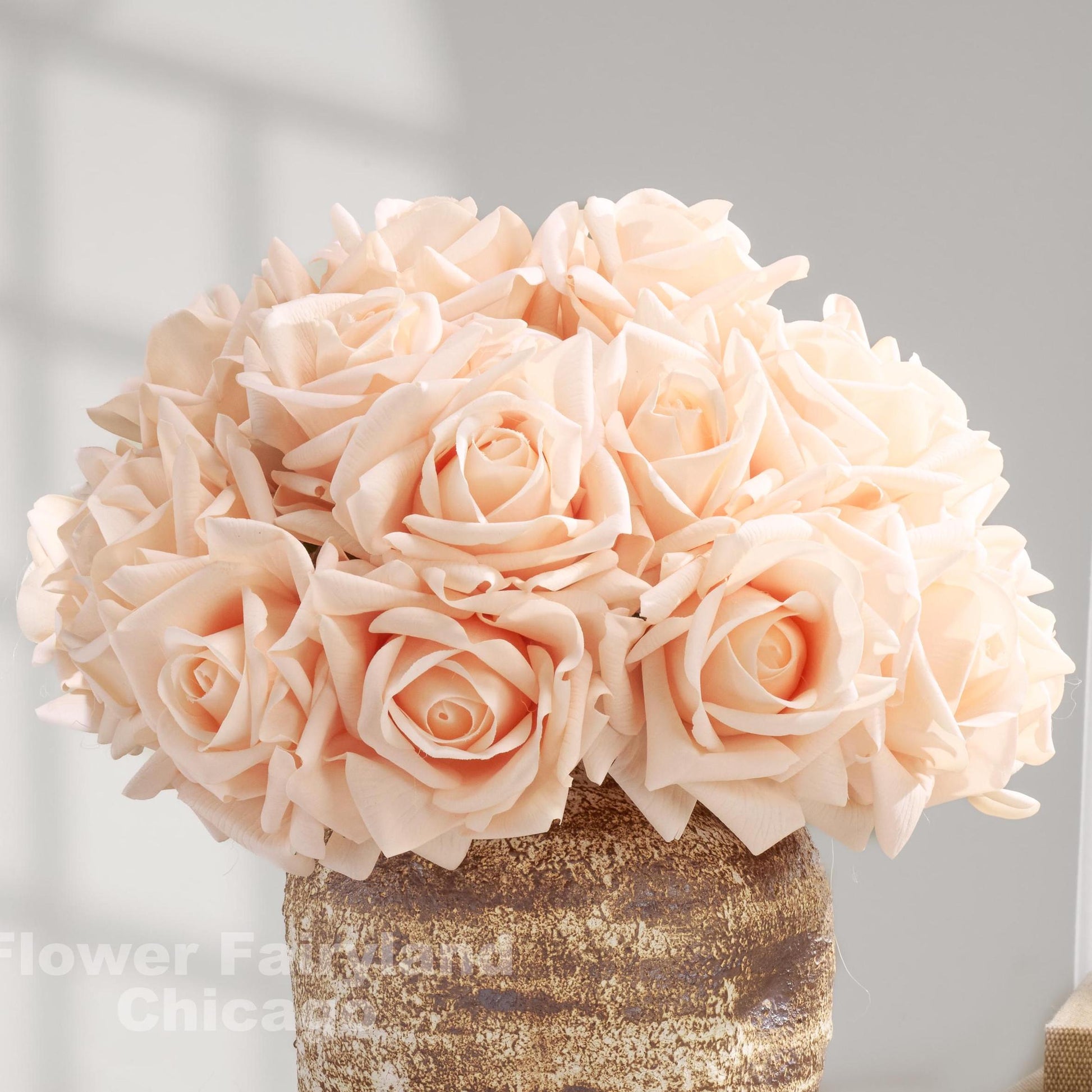 Soft peach rose arrangement in a textured vase