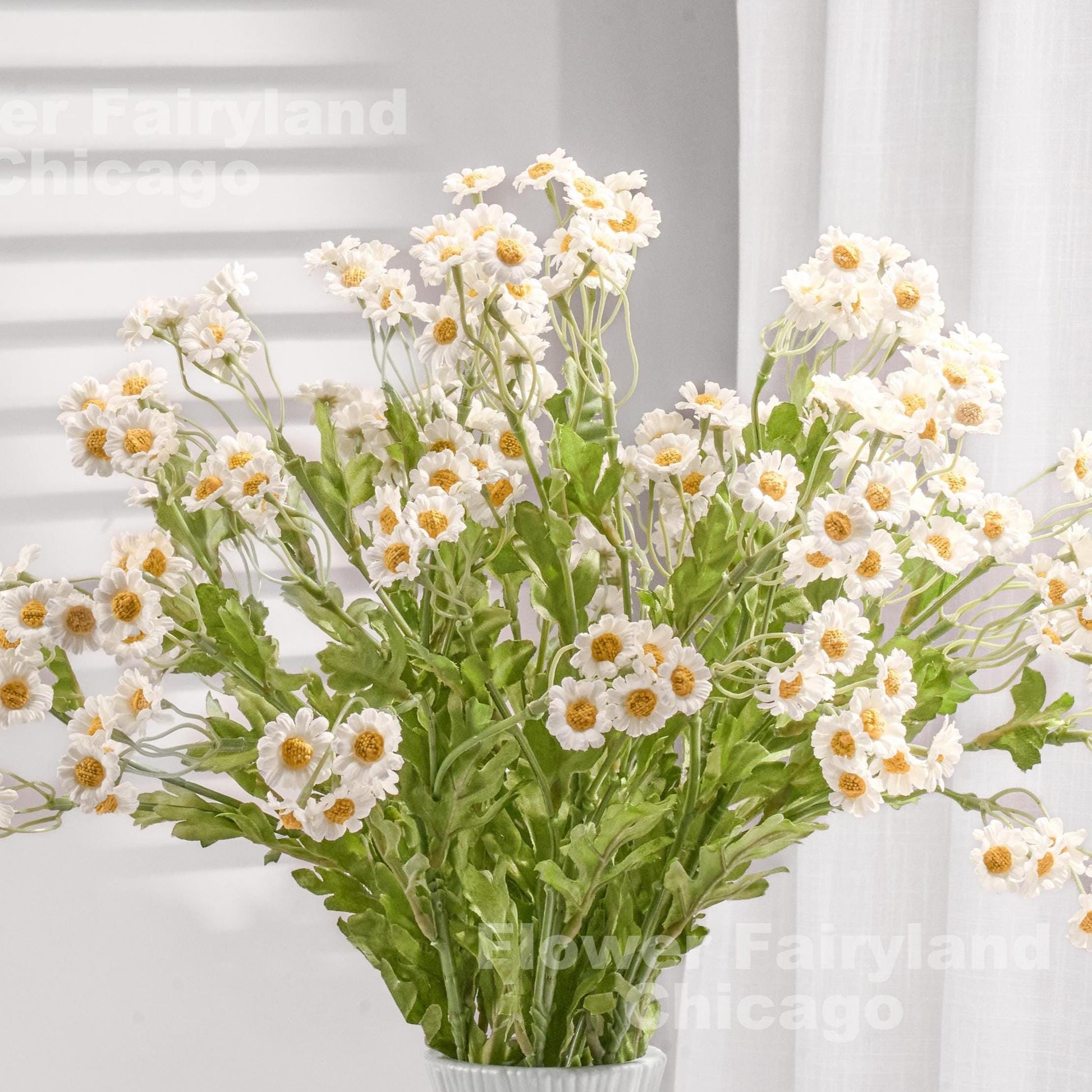 Bright white faux chamomile styled in a vase
