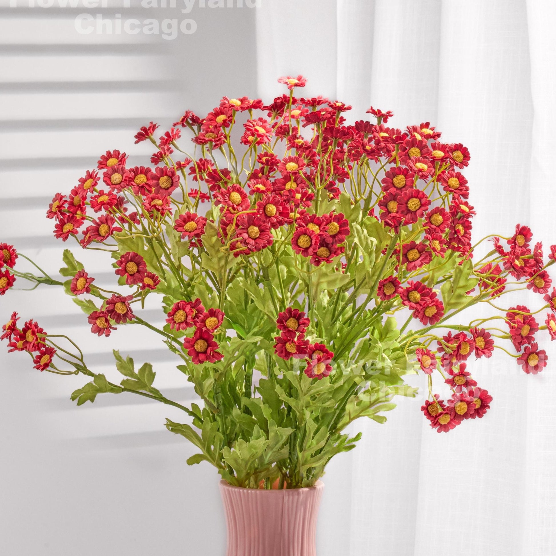 Red faux chamomile styled in a vase