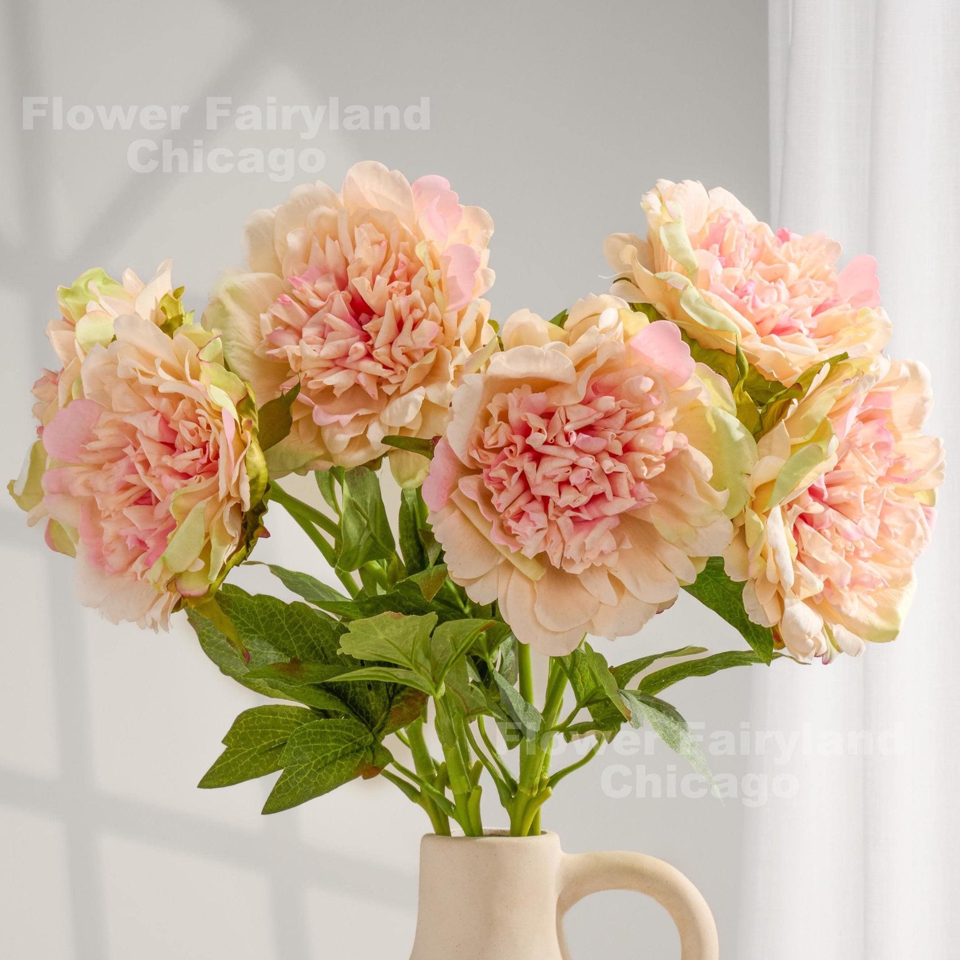 Pinky peach real touch peonies arranged in a cream vase