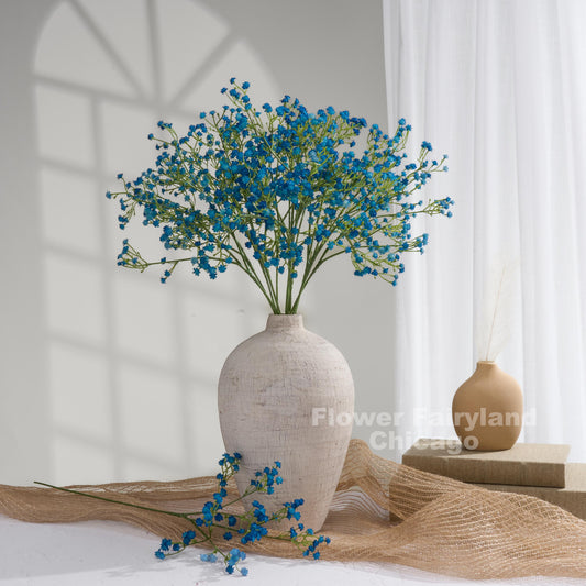 Faux baby's breath stems in dark blue styled in a vase
