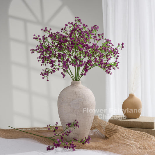 Faux baby's breath stems in dark purple styled in a vase
