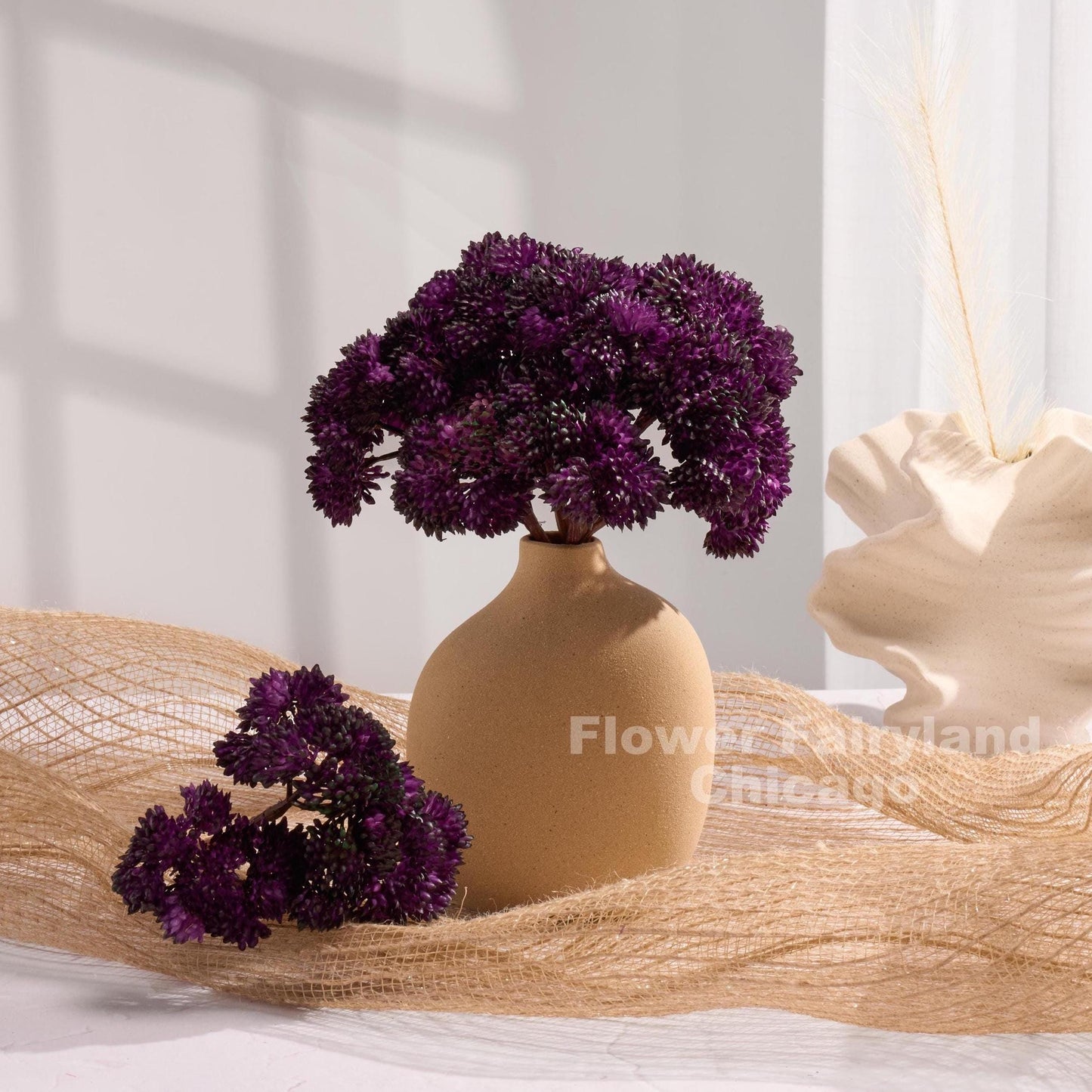 Dark purple sedum cluster arrangement in a vase