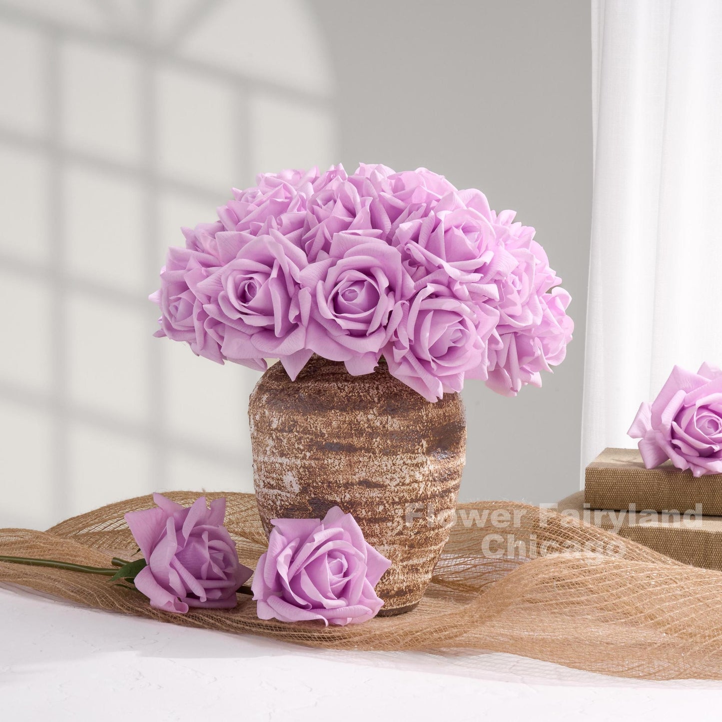 Lavender purple roses arranged in vase with loose stems