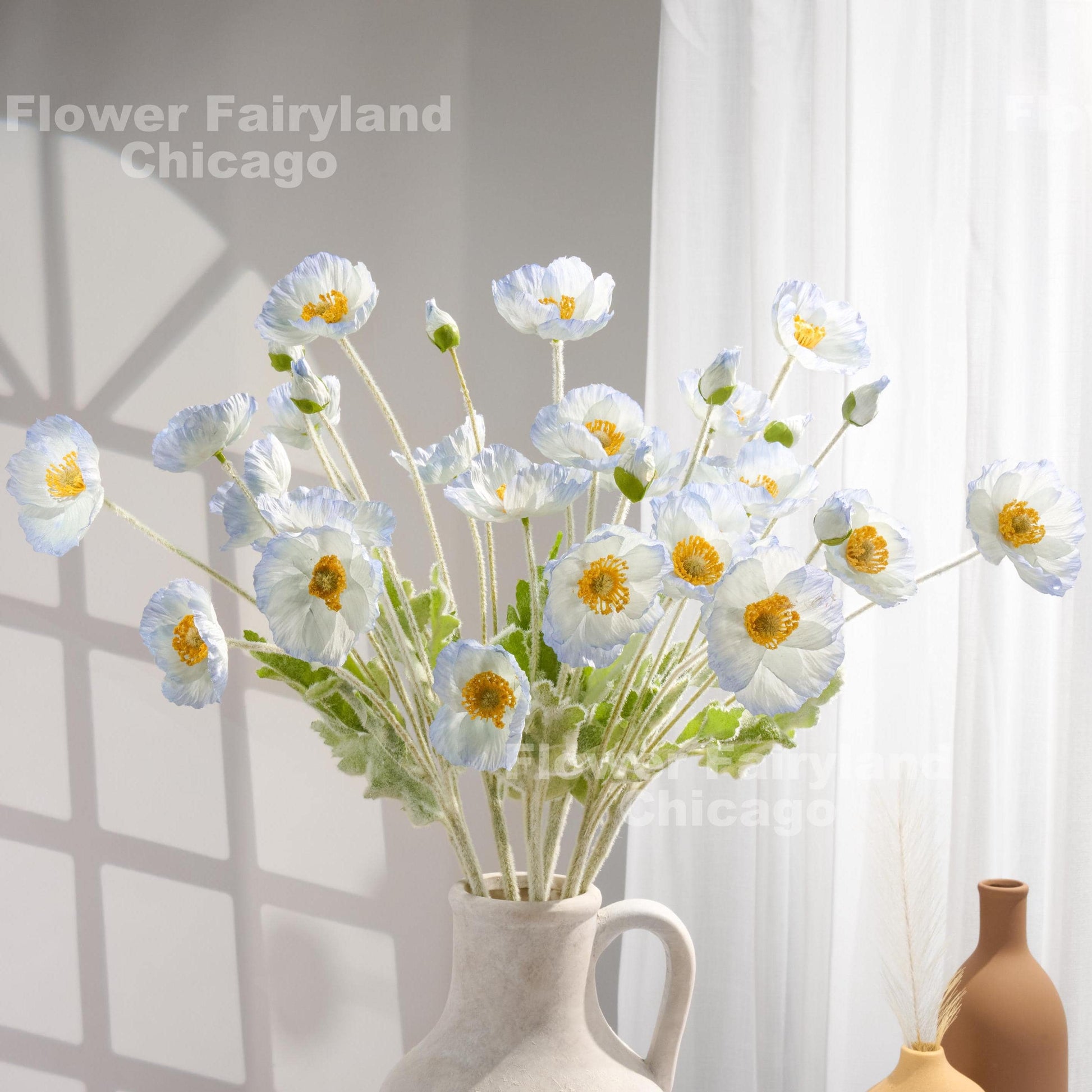 Ice blue faux poppy stems in a vase
