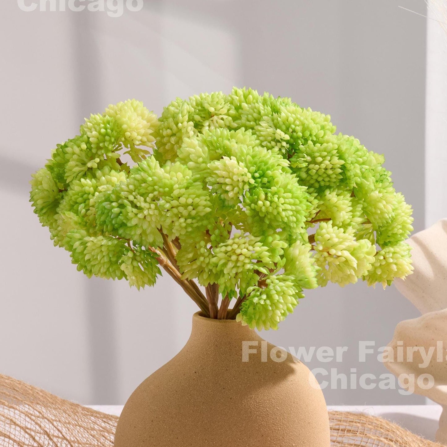 Light green sedum clusters styled in a vase