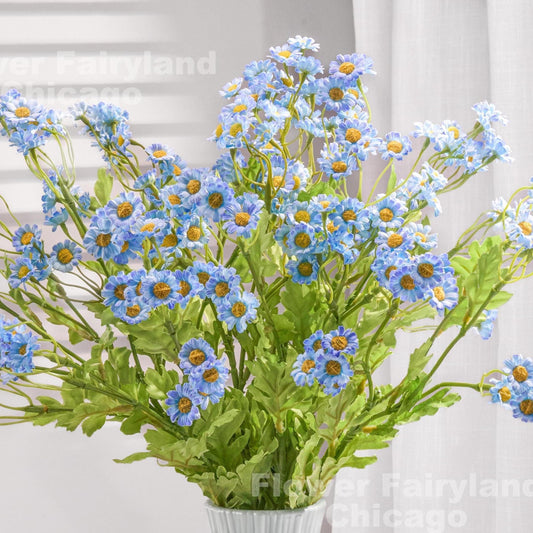 Blue faux chamomile styled in a vase with greenery