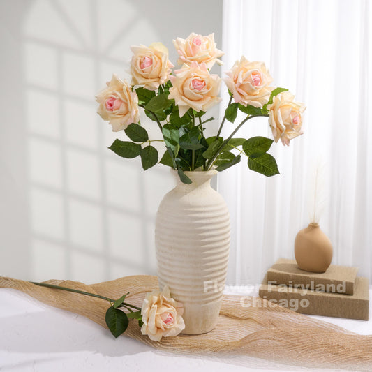 Pinky peach roses styled in a cream vase