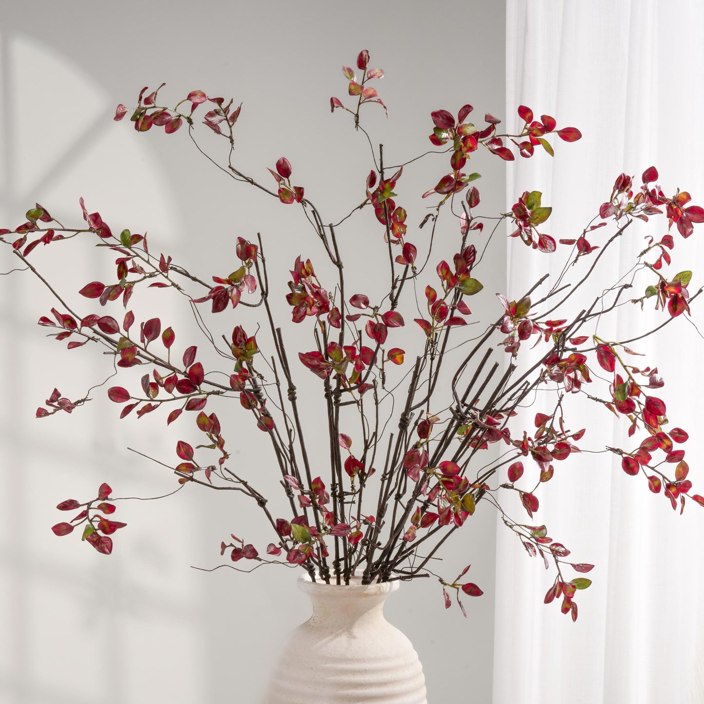 Burgundy faux branch arrangement in vase