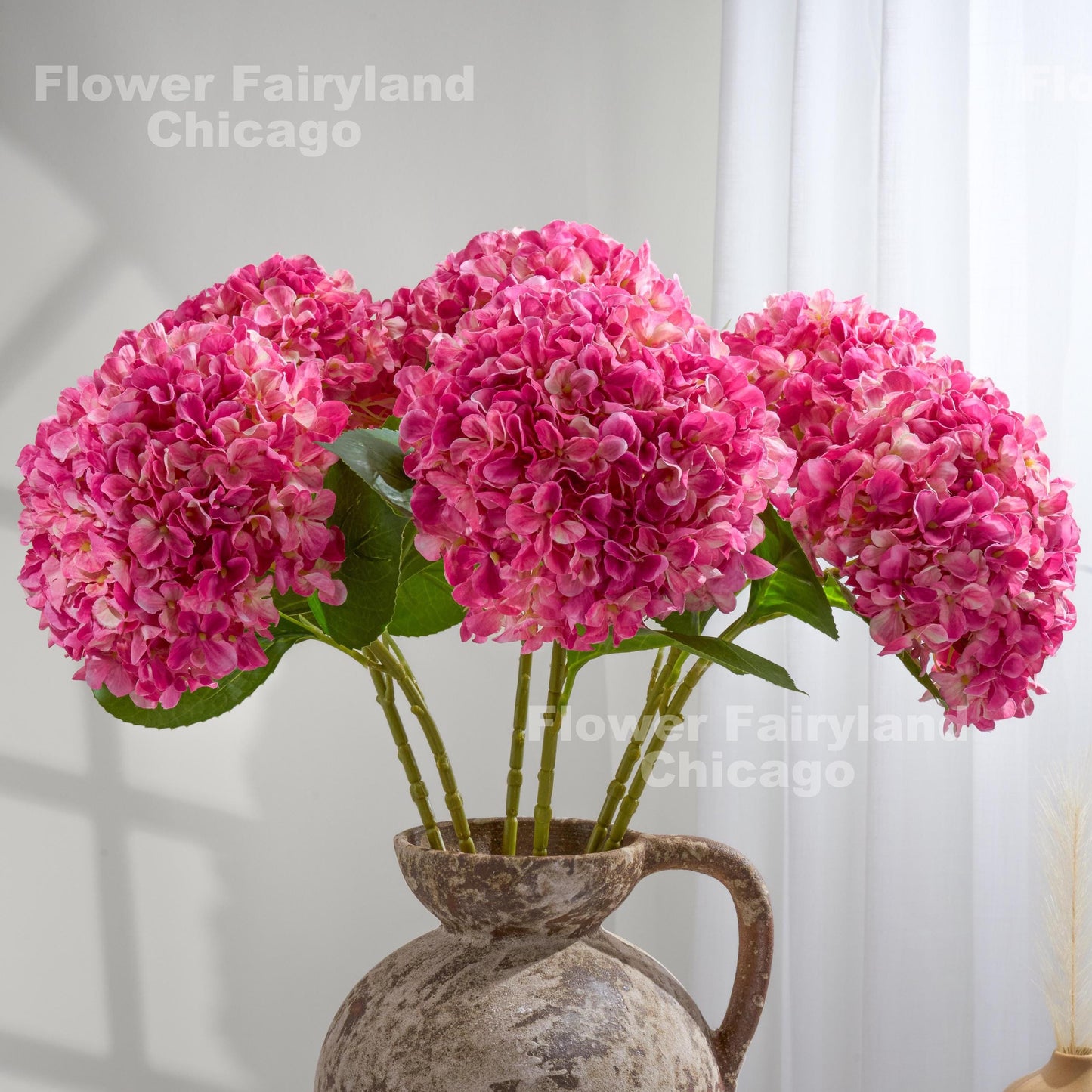 Bright pink faux hydrangea arrangement in a vase