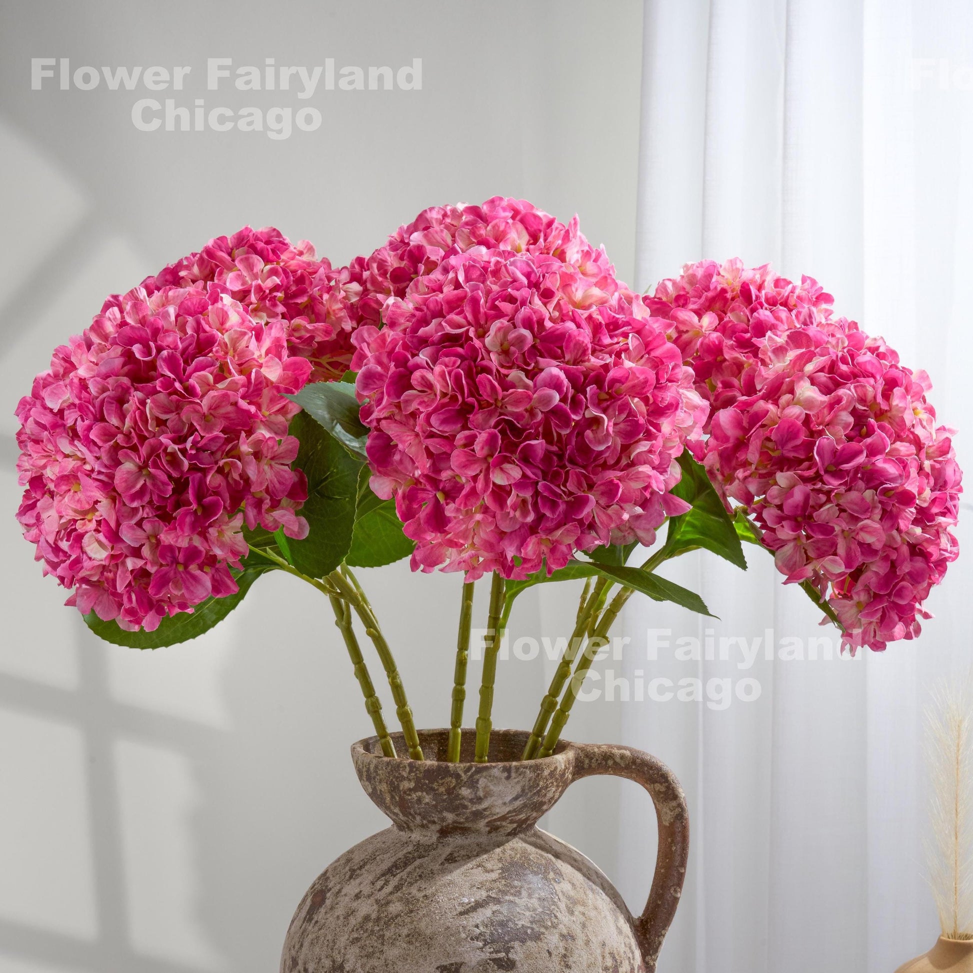 Bright pink faux hydrangea arrangement in a vase