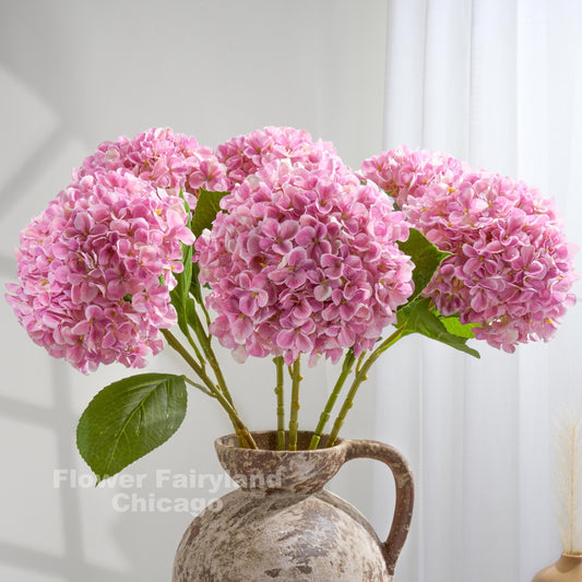 Purplish pink Grand Bloom faux hydrangeas styled in a vase