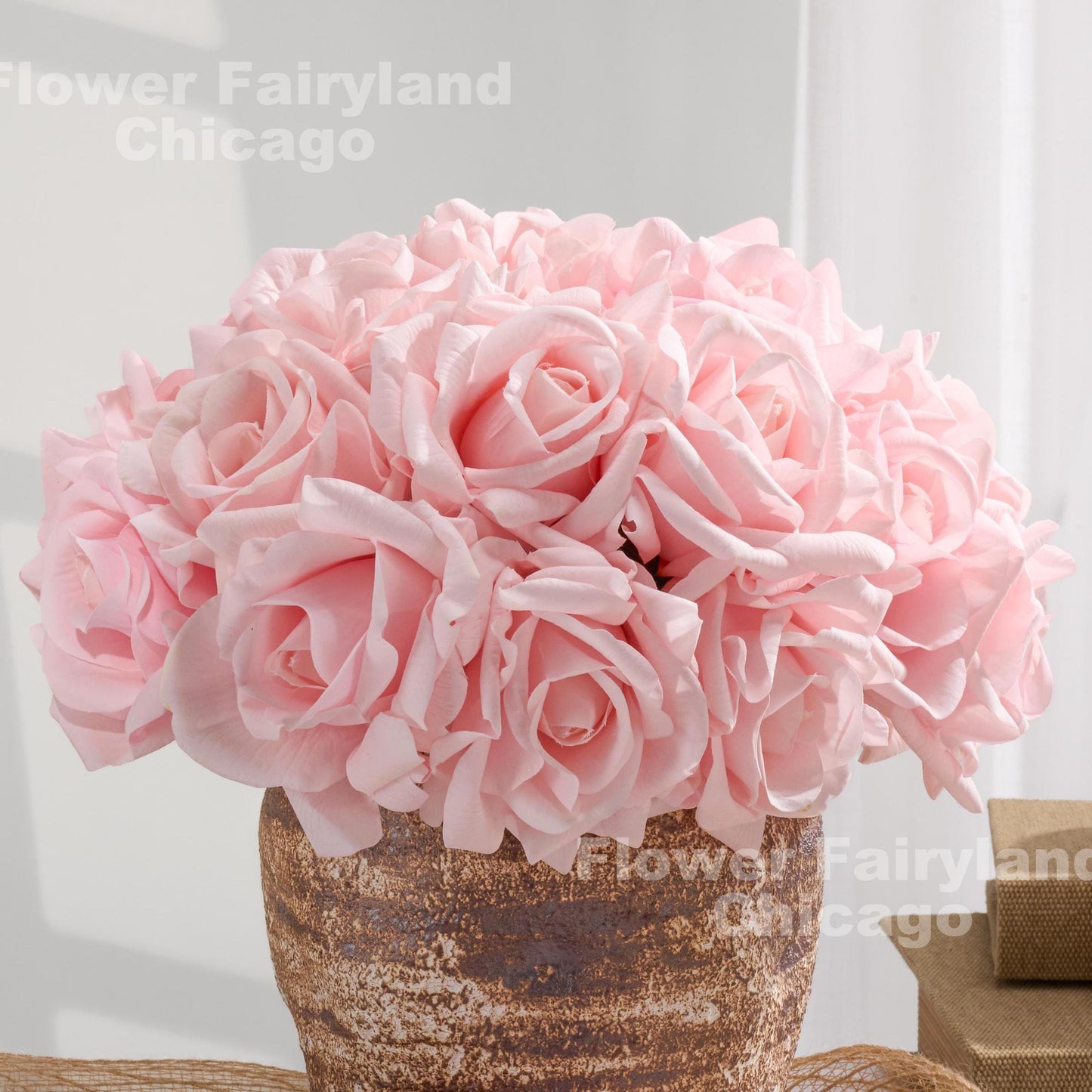 Blush pink roses arranged in a textured vase