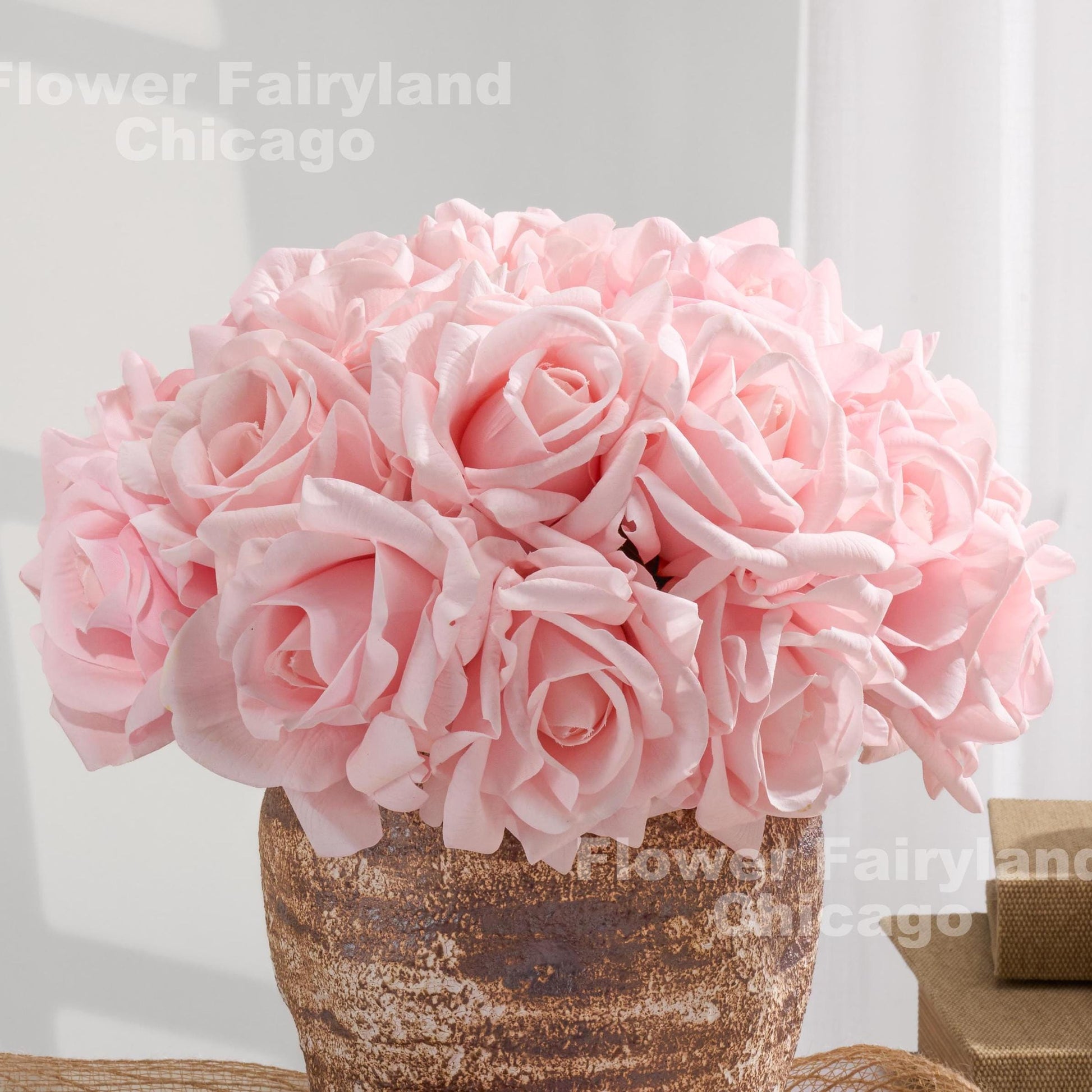 Blush pink roses arranged in a textured vase