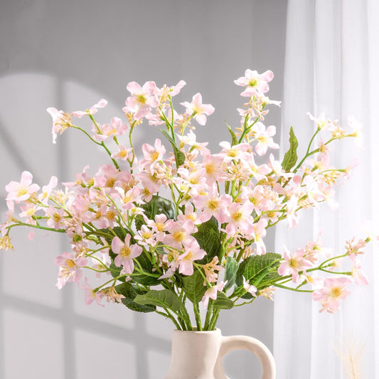 Light pink faux Vernicia blossoms styled in a vase