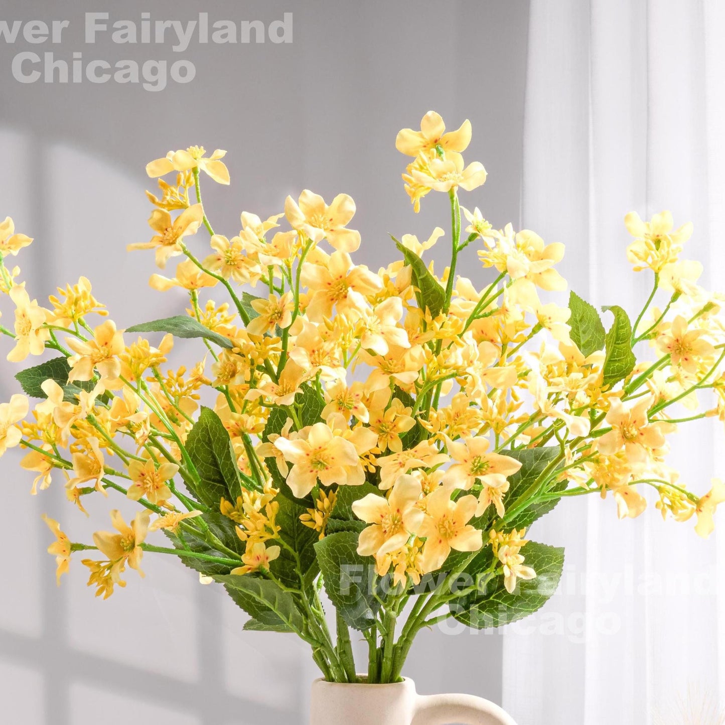 Yellow faux Vernicia blossoms held in hand