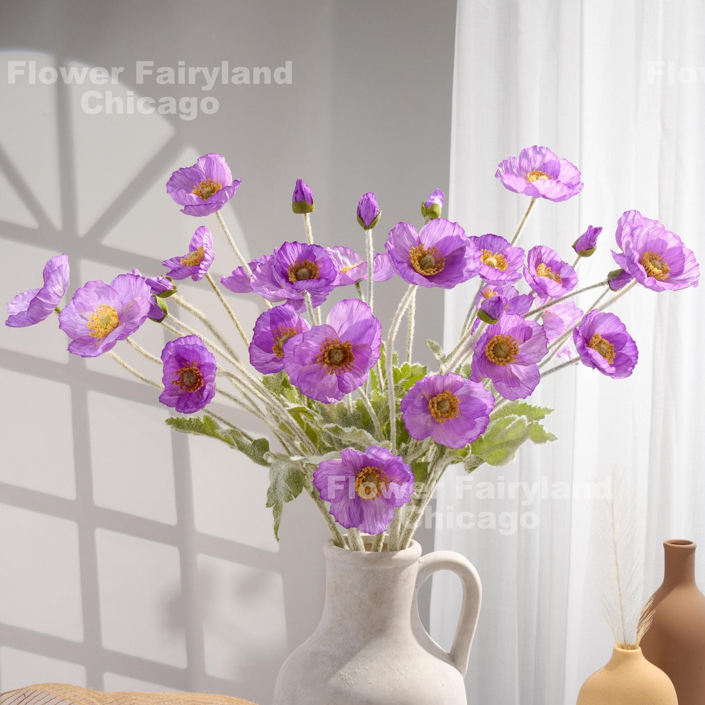 Violet purple faux poppy stems in a vase