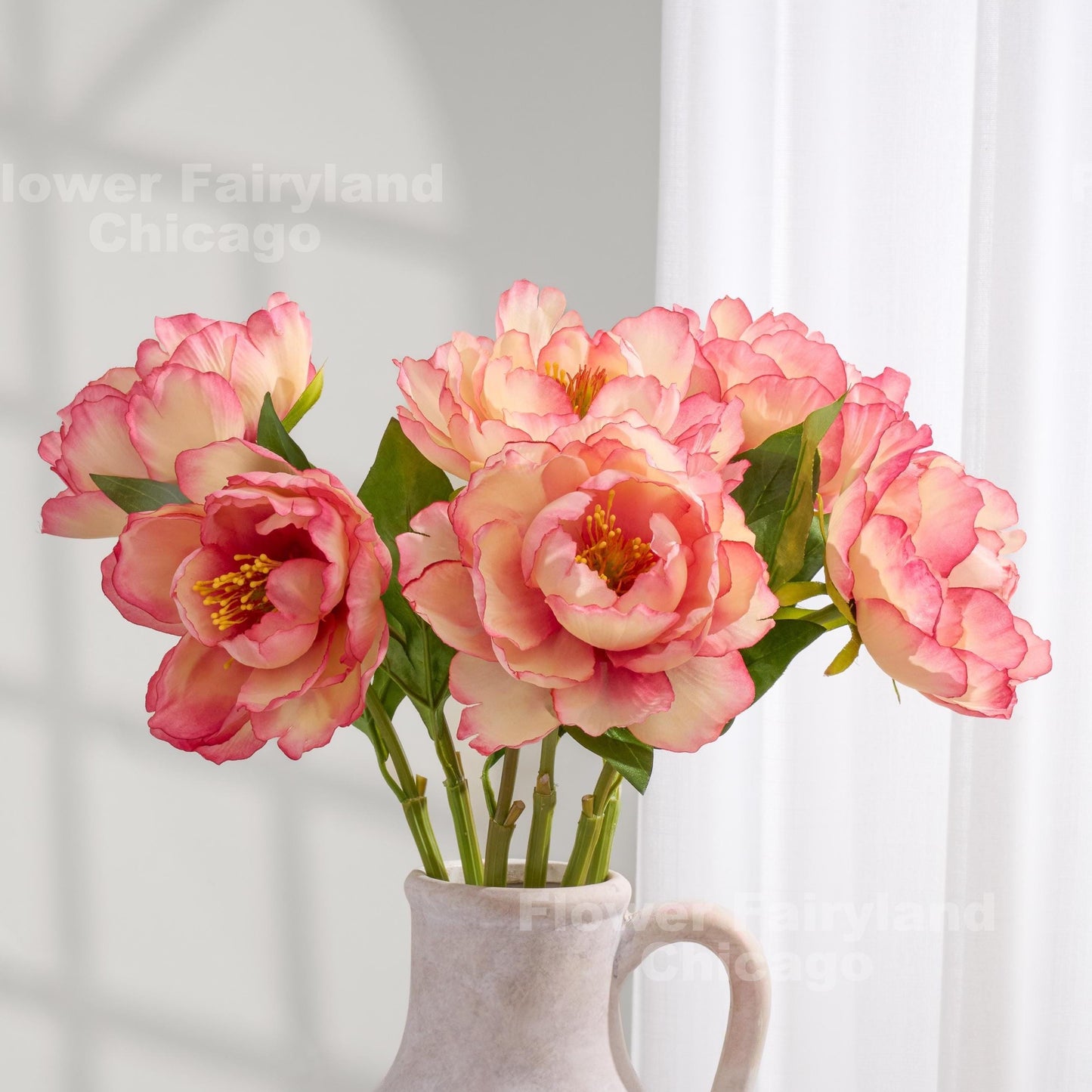 Coral faux peonies styled in a pitcher vase