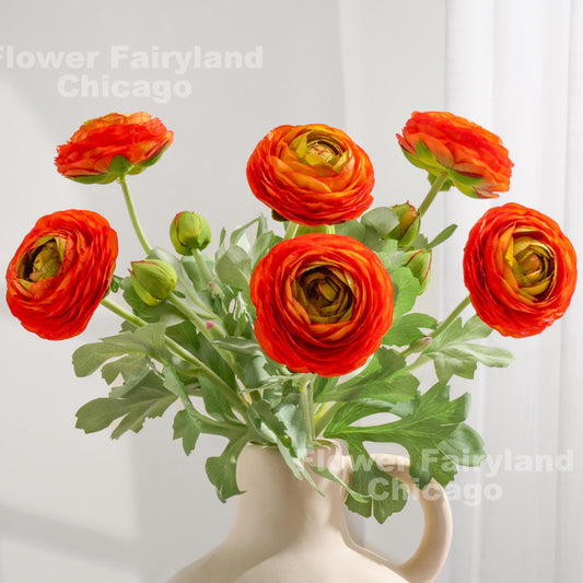 Orange faux ranunculus stems in a vase