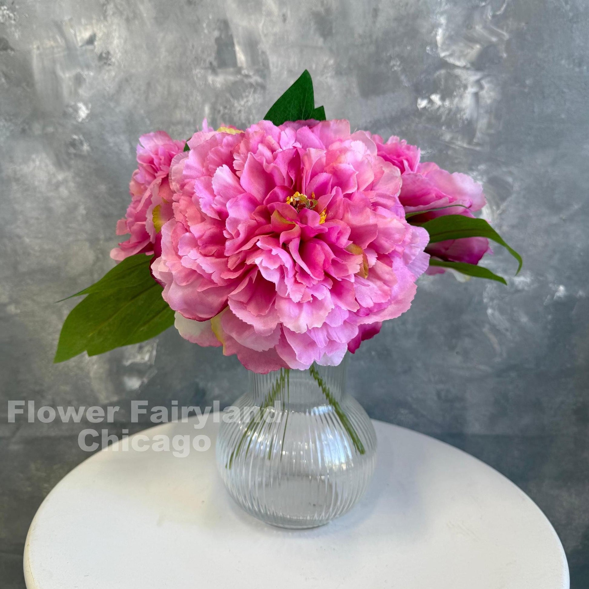 Bright pink huge peony blooms in a vase