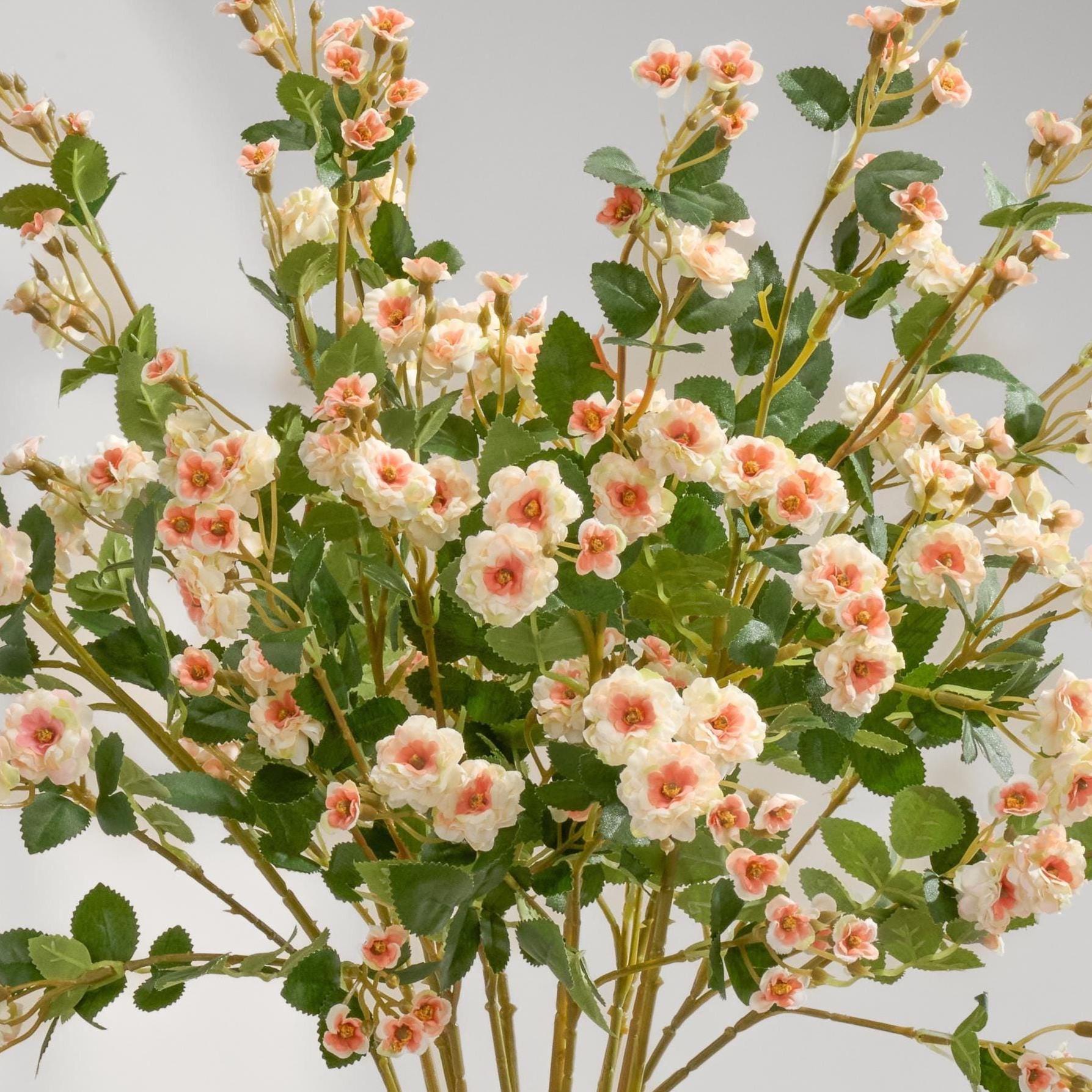 Peach faux miniature rose stems in a vase