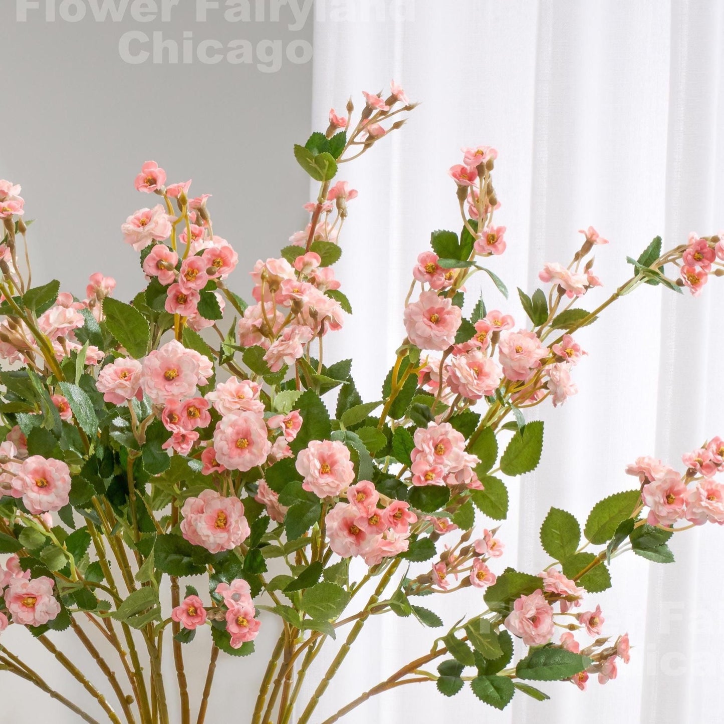 Light pink faux miniature rose stems in a vase