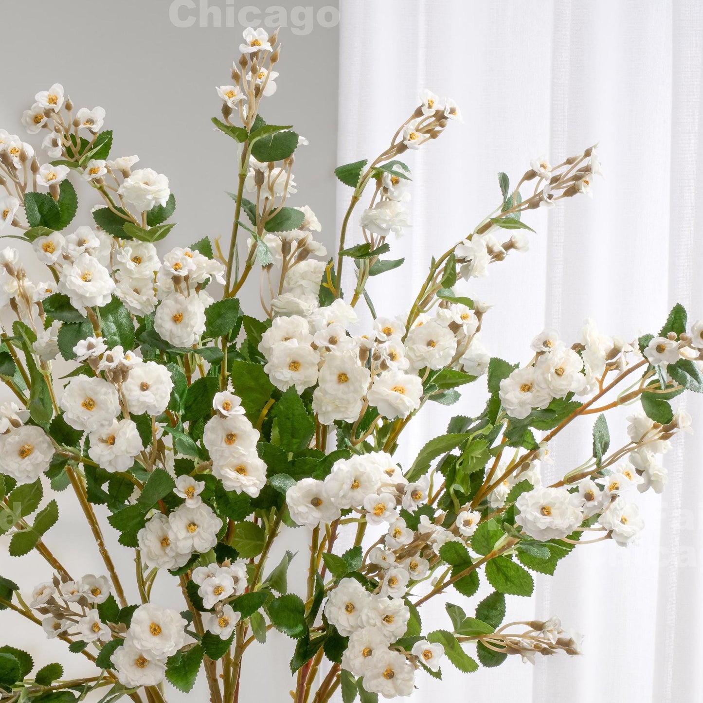 White faux miniature rose stems in a vase