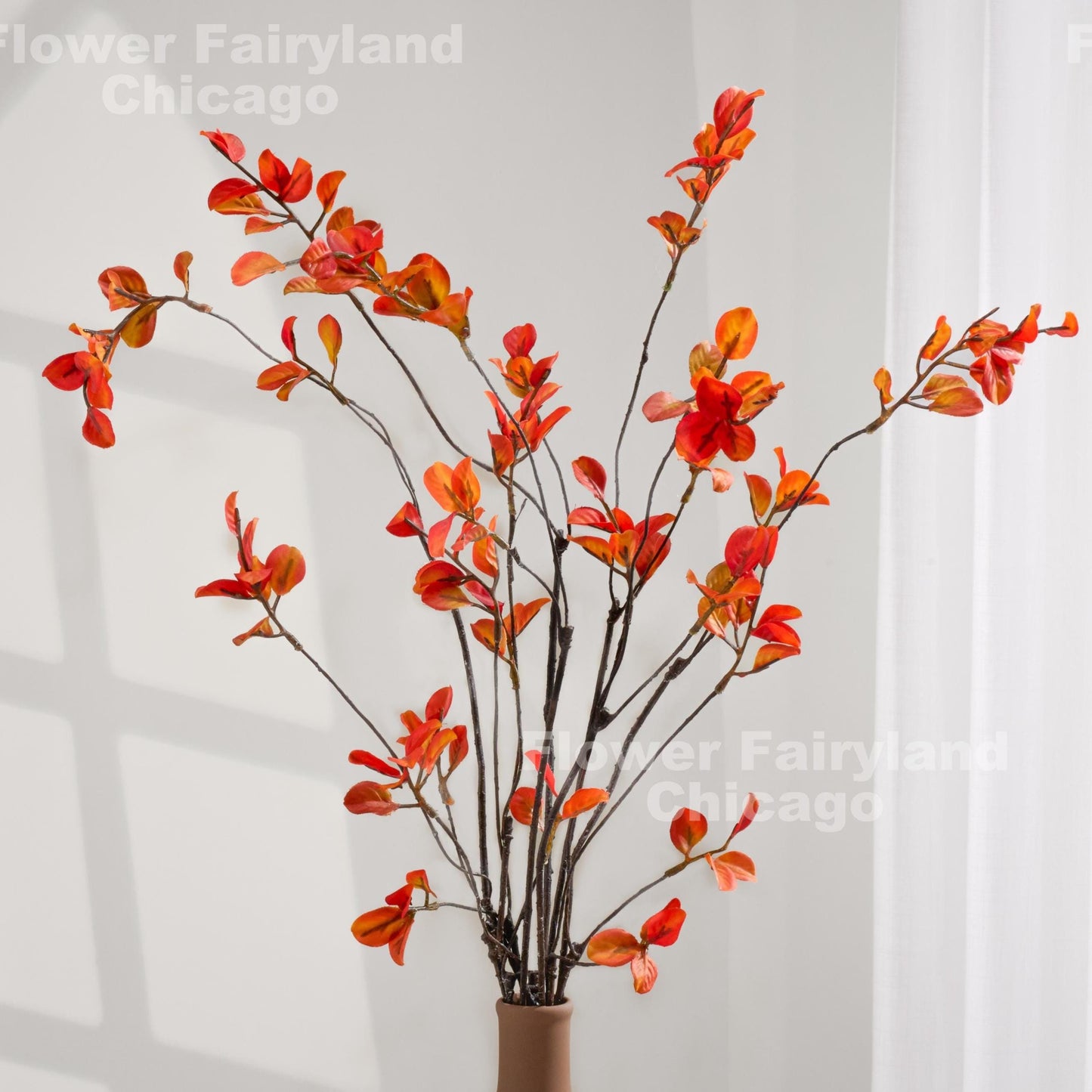 Orange minimalist leaf stems styled in a vase