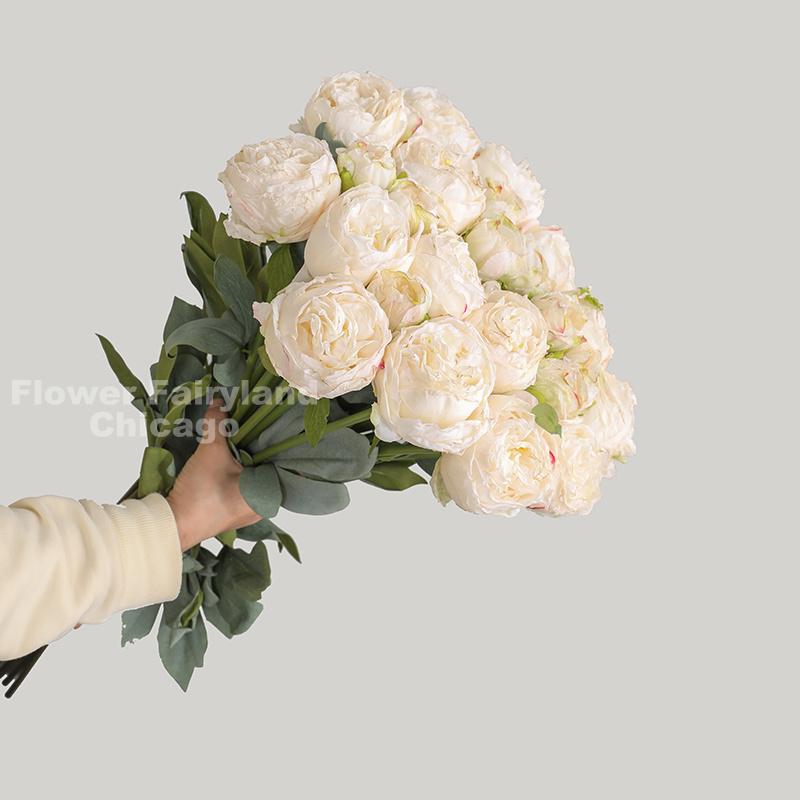 Milky white dried look peony and rose bouquet in a vase