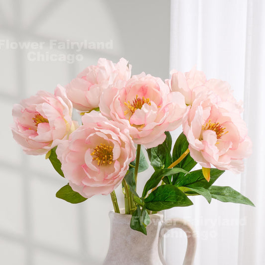 Light pink faux peonies styled in a pitcher vase