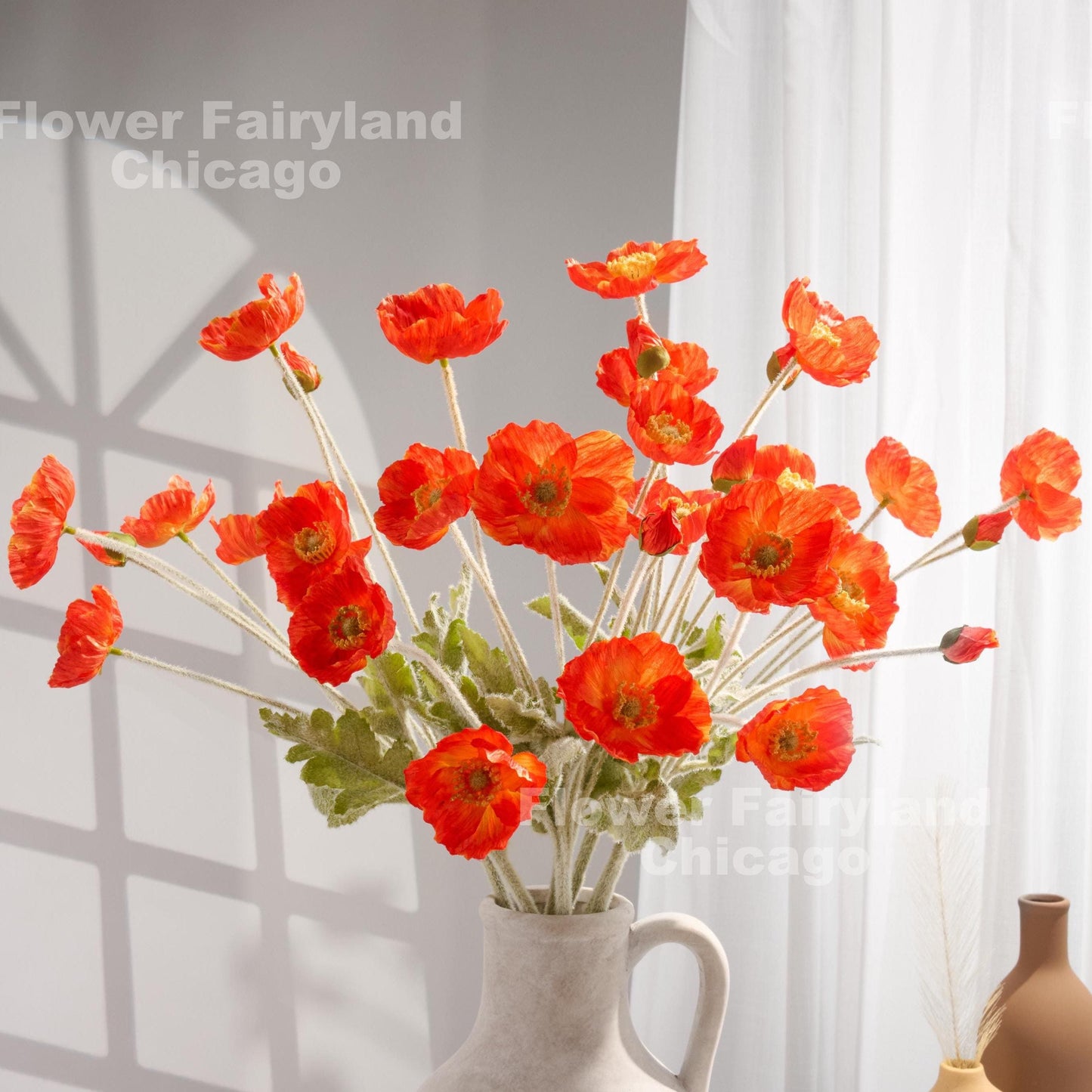 Bright coral red faux poppy stems in a vase